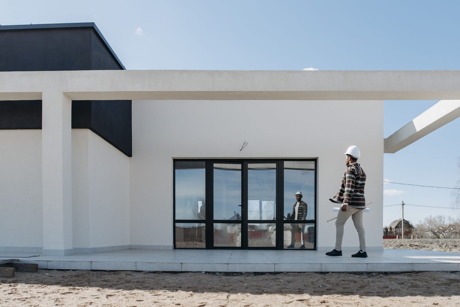 Bausachverständiger mit Bauplänen begutachtet einen Neubau